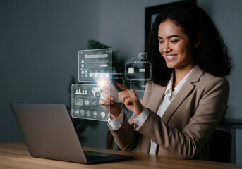 A woman engages with digital technology while working on her laptop in a modern office setting during the daytime