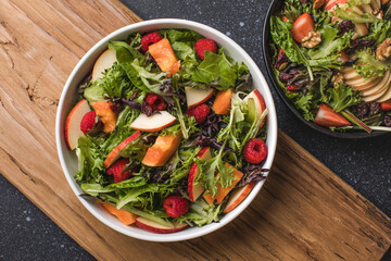 Tasty salad with apple, papaya, lettuce, top view.  Vegetable salad.