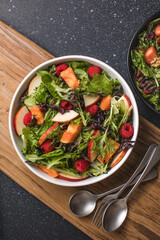 Tasty salad with apple, papaya, lettuce, top view.  Vegetable salad.