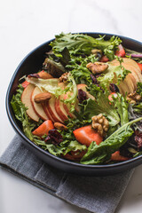 Tasty salad with apple, papaya, lettuce, top view.  Vegetable salad.