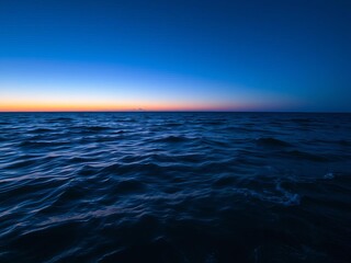 Obraz premium A stunning sunset view of the vast and tranquil ocean filled with vibrant colors reflecting in the water, creating a sense of peace and serenity, waves, serenity