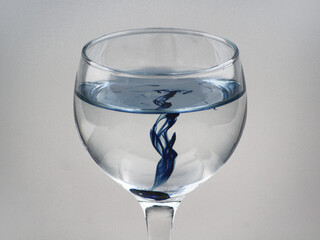 Blue Ink in a wine glass with clean water