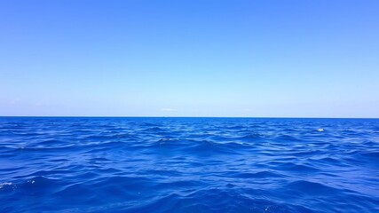 Fototapeta premium A serene ocean background featuring crystal clear blue waters and a cloudless sky, perfect for tranquil and peaceful designs, nature, vacation