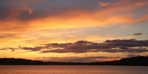 A serene landscape showcasing a colorful sunset over a tranquil lake, reflection, colorful