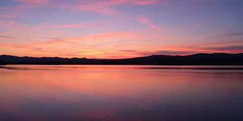 Naklejka premium A serene landscape at dusk with a colorful sky reflecting on a calm water surface, creating a peaceful and picturesque scene, water, calm