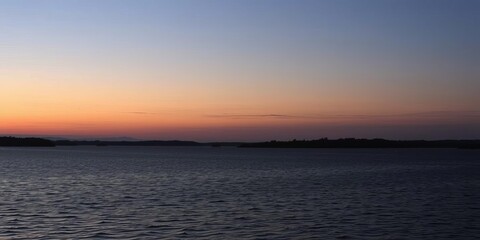 Obraz premium A serene lake at dusk, with the last light of the sun reflecting on the still water, lake, dusk sky