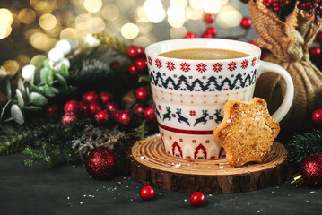 Christmas themed coffee mug with a cookie,christmas decorations and christmas lights. Christmas concept background
