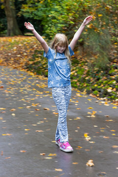 Girl (8-9 years old) on 'Heely's' wheeled shoes skating down hill