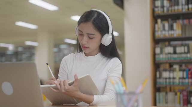 Young asian college student online learning course on laptop