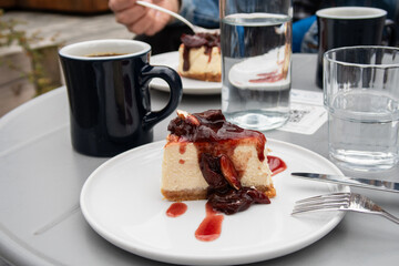 a cup of black coffee and a delicious cheesecake