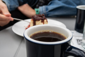 a cup of black coffee and a delicious cheesecake