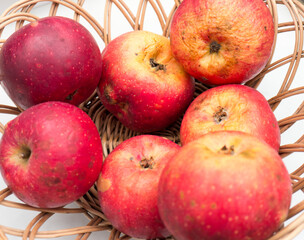 Overripe apples in a wooden plate.