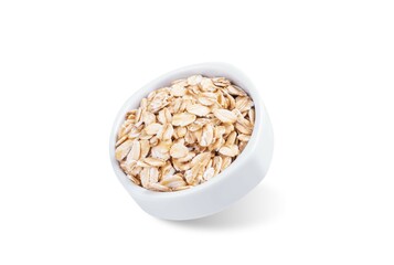 Raw dried oats in a bowl on a white isolated background