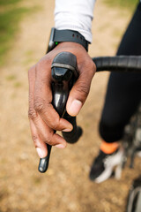 Cyclist hand holding bicycle brake lever while riding