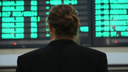 Businessman traveller man in airport near flight timetable, train bus station. Business man in jacket with luggage at airport terminal arrivals table. Waiting for flight delay plane In terminal