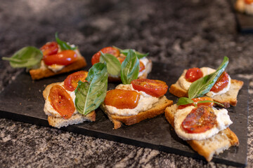 Primer plano bruschettas con queso tomate y albahaca