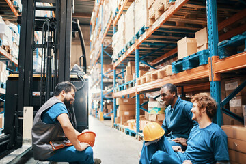 Warehouse workers taking a break and chatting in storage aisle