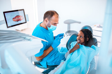 Professional dentist working on a little girls teeth in his dental office