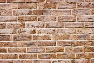 Brown brick wall. Horizontal decorative uneven blocks. Urban architecture texture. Solid stone...