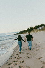 couple running on a beach at sunset