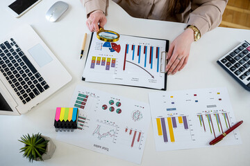 Young businesswoman doing paperwork or analyzing work results at modern office