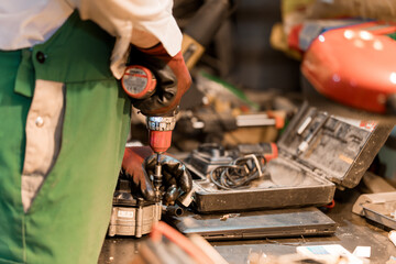 Mechanic Working on Equipment with Power Tools in a Workshop Environment