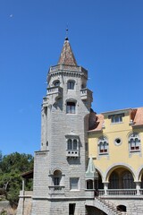 Fototapeta premium Cascais, Portugal - August 16 2016: Charming Stone Tower of Palace of Counts of Castro Guimaraes Under Clear Blue Sky