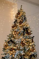 Elegant Christmas Tree Adorned with Golden Ornaments and Twinkling Lights