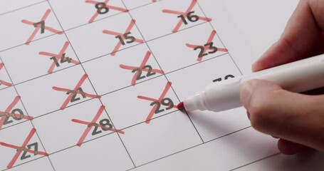 Close-up of a hand marking off days on a calendar with a red marker. Concept of time management, scheduling, and planning. Hand Marking Off Days on Calendar with Red Marker, Close-Up View