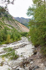 Stormy flow of a mountain mestiachala river. Active recreation and hiking. Gloomy rainy weather. Beginning of the route to Chalaadi Glacier Georgia