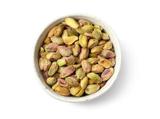 Peeled pistachio nuts in bowl isolated on white, top view