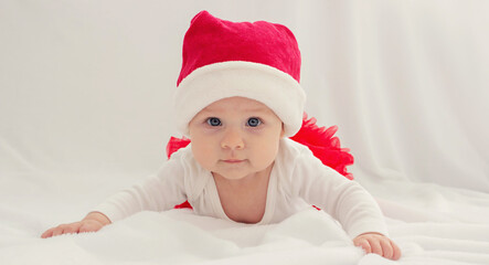 Baby girl in a Santa hat on a light background.holiday.