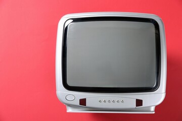Retro tv set on red background, top view