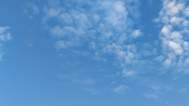 Clouds are floating in sky. Blue sky with white cirrus clouds that are moving sedately across the sky. They are located at different heights and almost do not change their shape and size as they move.