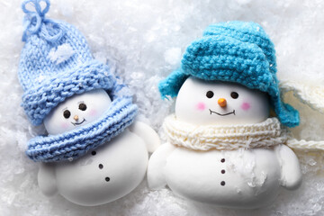 Cute decorative snowmen on artificial snow, top view