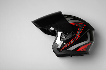 Modern motorcycle helmet with visor on gray background, top view. Space for text