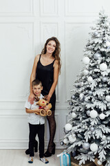 Mom and son Christmas tree with gifts for the new year
