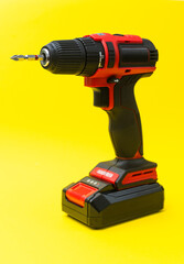 Modern cordless electric screwdriver on yellow