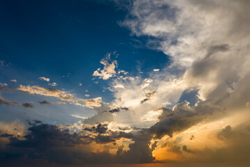 Obraz premium Bright sunset with setting sun behind vivid orange and yellow clouds