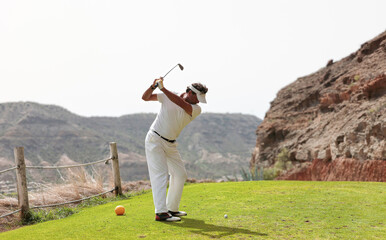 The golfer hits the golf ball with the Drive in his hand, on the tee.