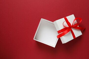 Beautiful gift box tied with bow on color background 