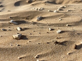 close-up of sand dunes with small stones, natural desert texture