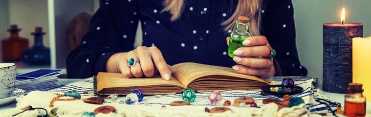Woman fortune teller reads a book of spells. Selective focus.