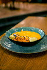Pumpkin puree soup with shrimp in a plate. Concept of autumn cuisine. Pumpkin dish