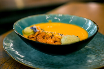 Pumpkin puree soup with shrimp in a plate. Concept of autumn cuisine. Pumpkin dish