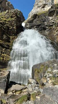 Cascada Cola de Caballo en el Parque Nacional de Ordesa, Espa&ntilde;a, rodeada de monta&ntilde;as y rocas bajo un cielo despejado