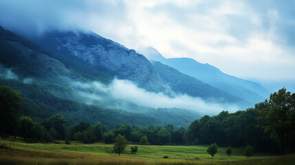 Naklejka premium Misty Mountain Range Landscape: Serene Blue Fog, Green Valley, Majestic Peaks