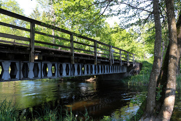 Old steel and wooden bridge over the river in Borki in Masuria, Poland