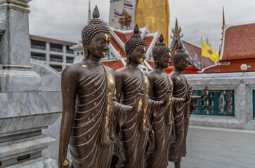 Details from statues of Buddha and monks in a temple in Bangkok