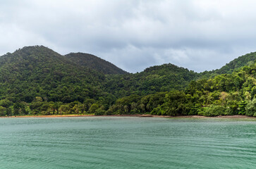 The beach and forested hills of Koh Chang in Thailand on a summer day